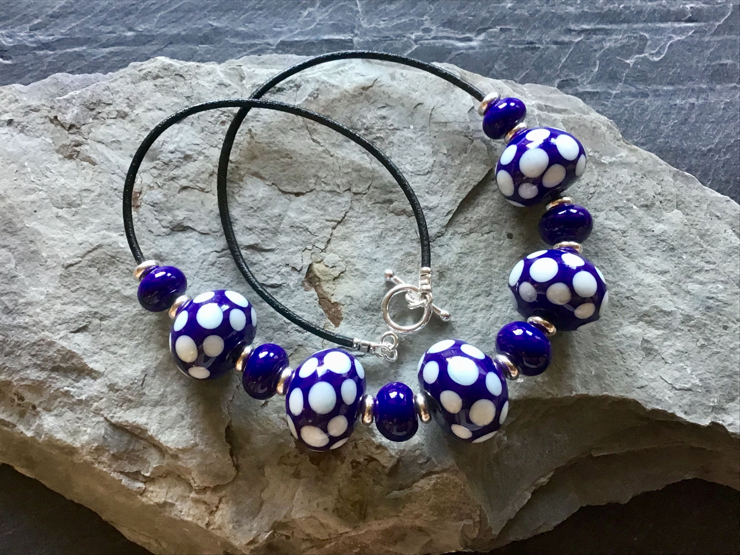 Purple and white polka dot necklace.