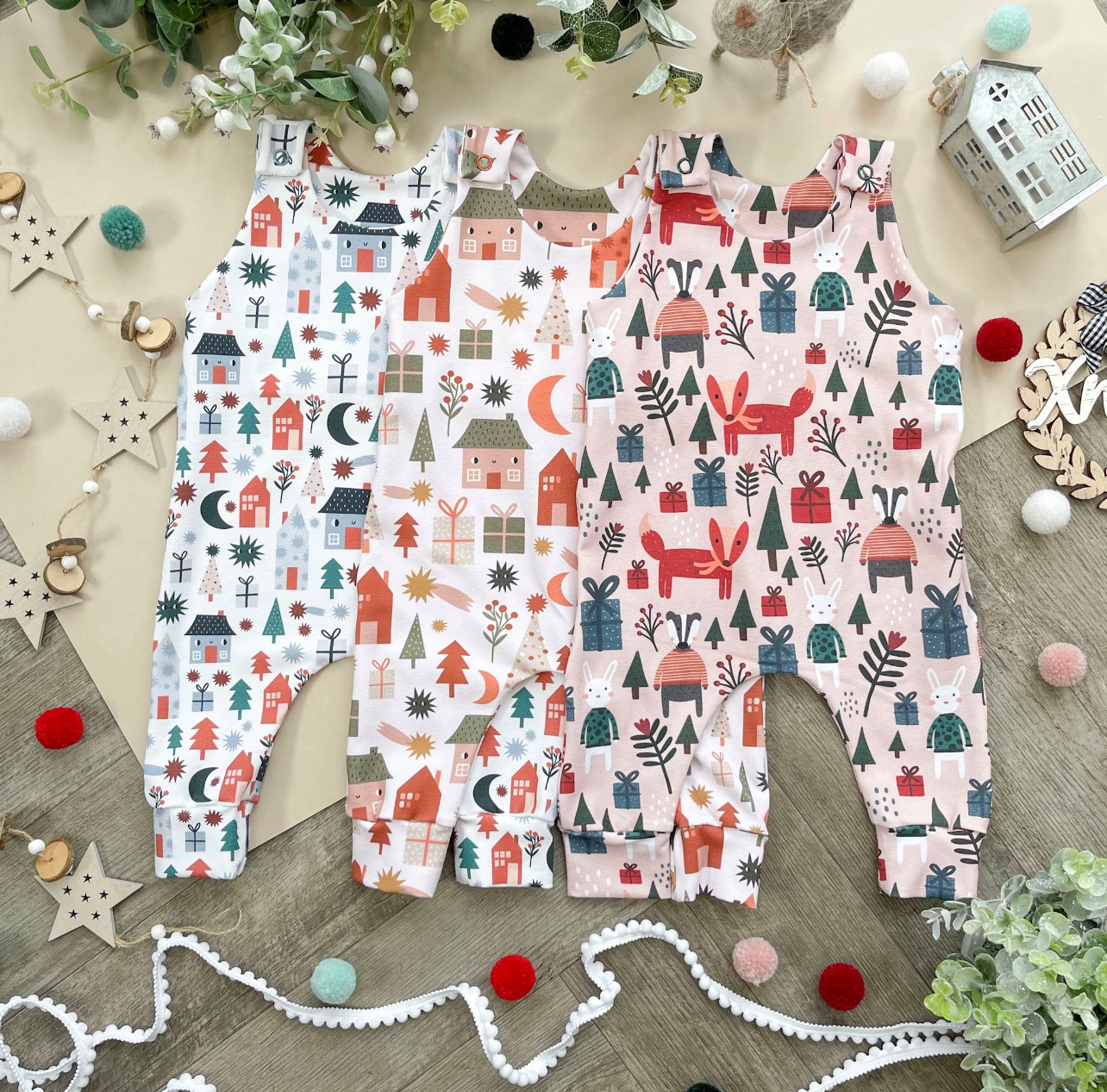Three Christmas-themed baby onesies.