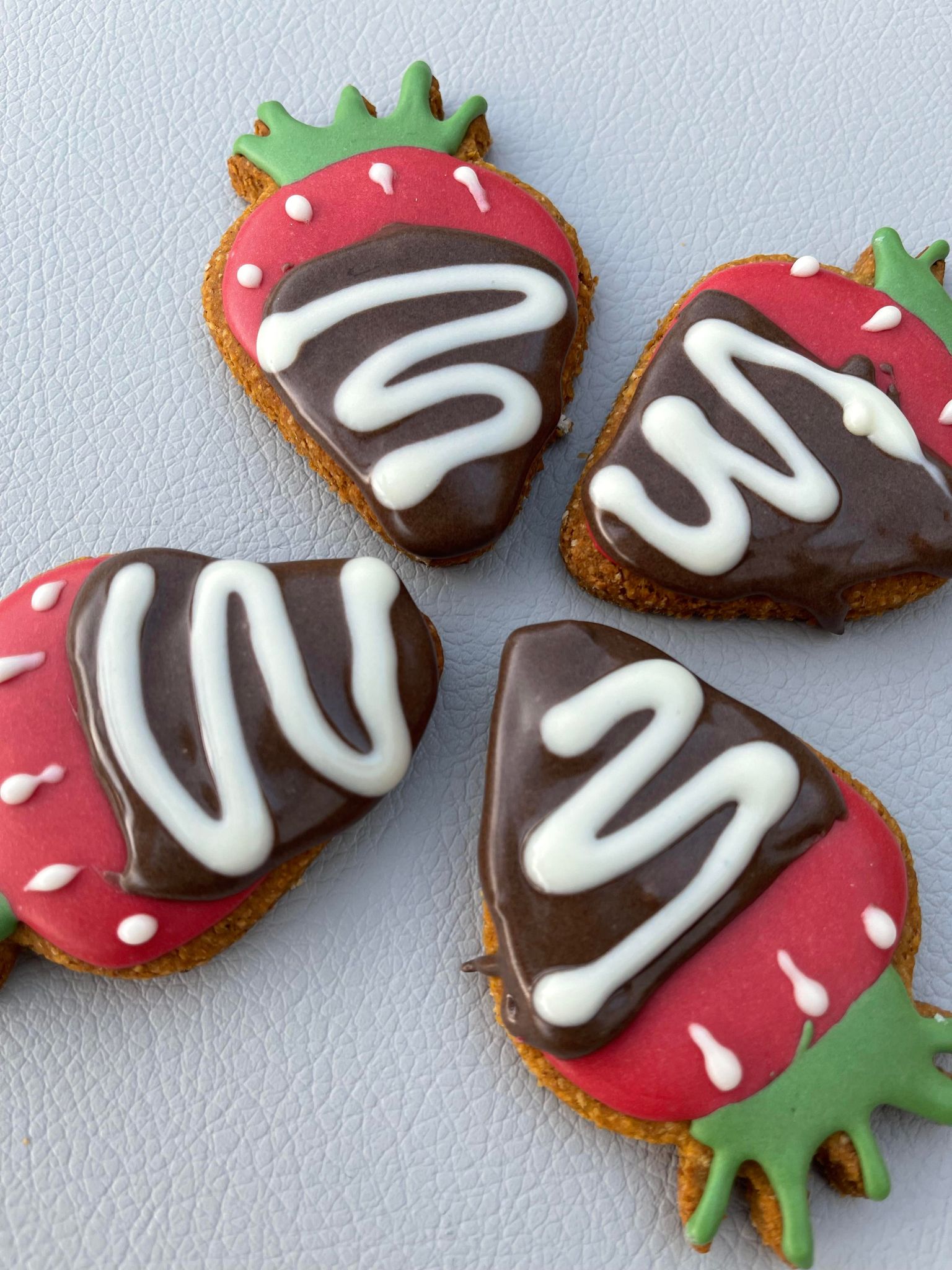 Four decorated strawberry cookies.