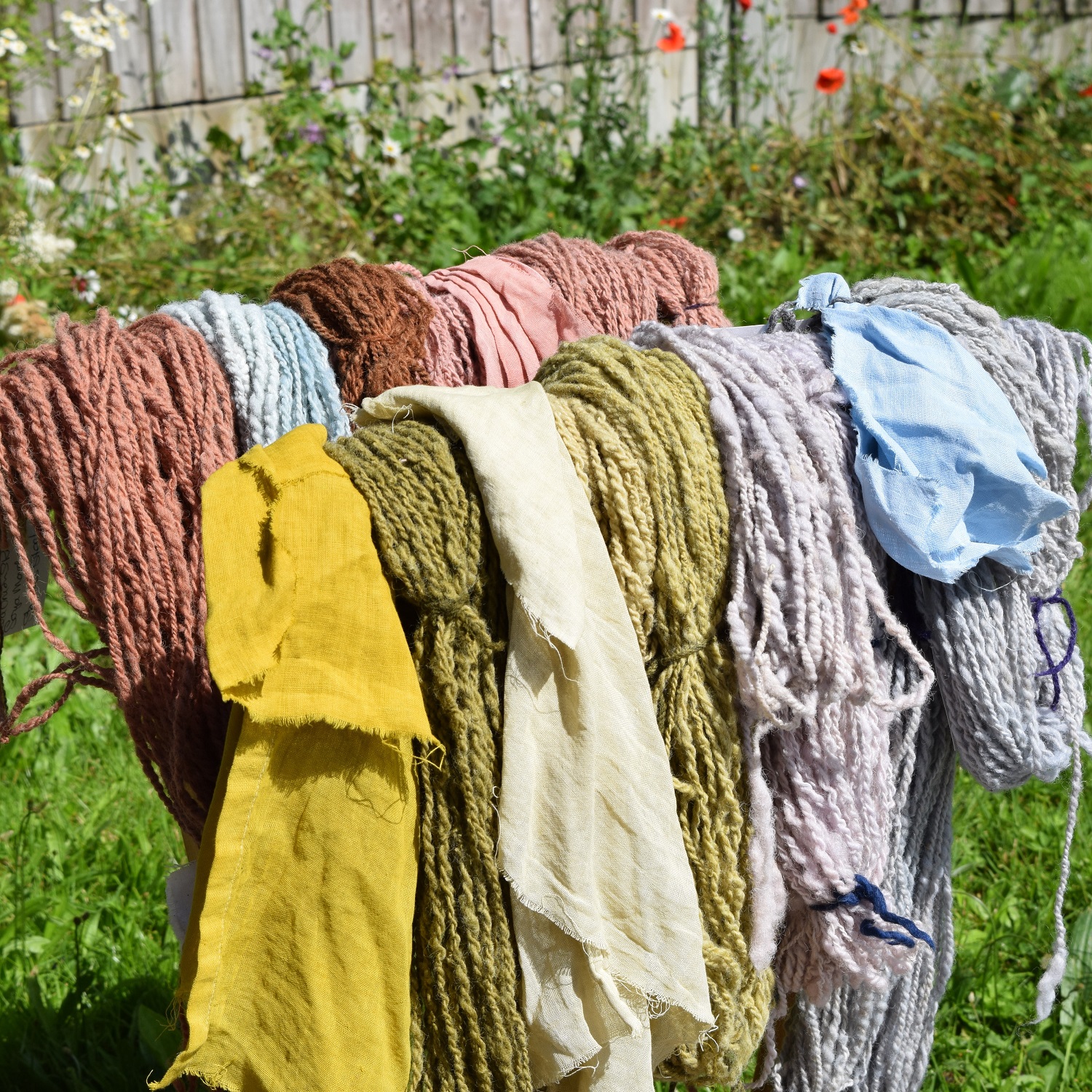 Colorful yarn and fabric hanging outdoors.